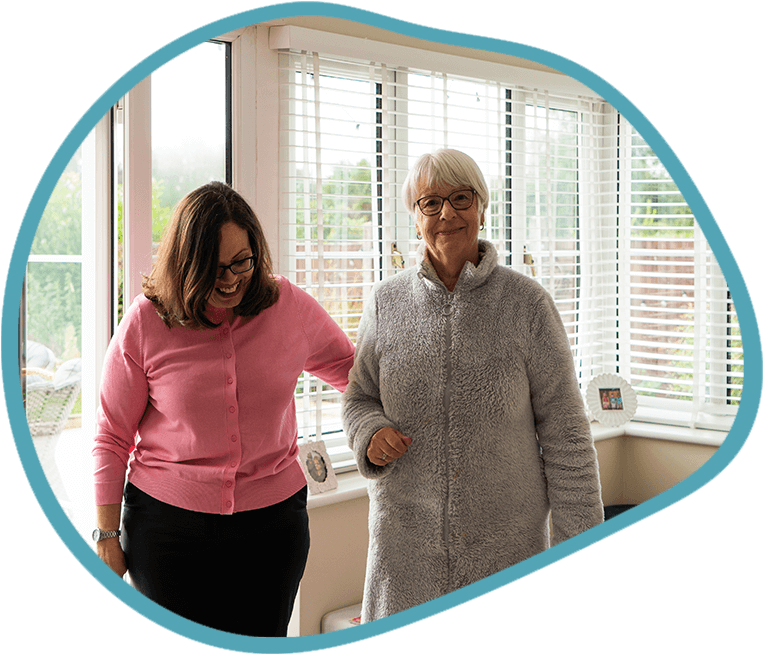 female carer and female client walking in the conservatory