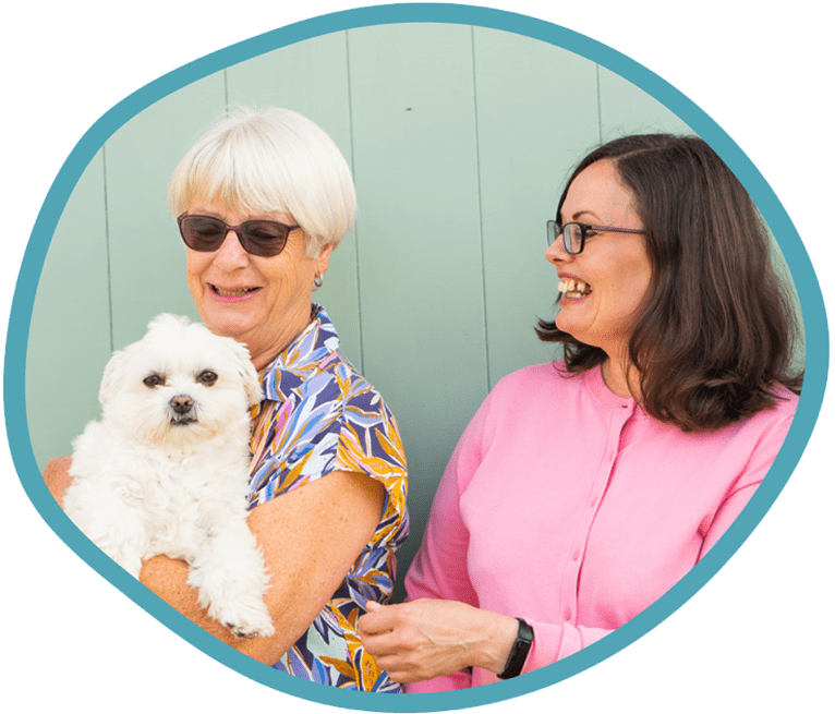 Female client and female carer outside together with their white dog